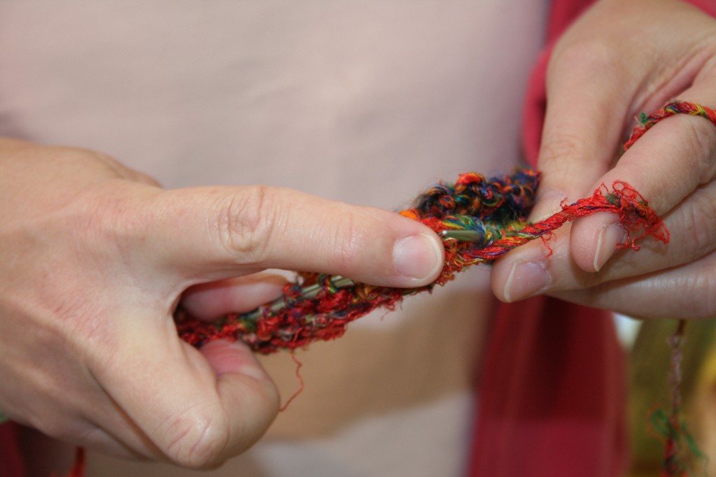 The hands of Knitting Out Louder founder, Kathy Goldner, knitting in public and trying out some recycled silk yarn at the 2010 Connecticut Sheep, Wool And Fiber Festival.